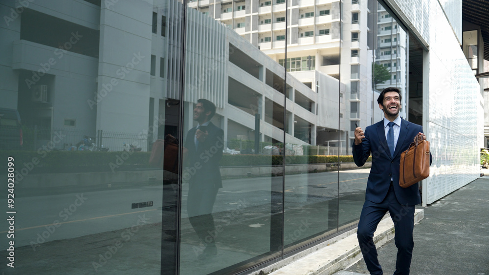 Skilled smart business man dancing with joyful while walking in glass wall. Project manger receive a good news, getting promotion, getting a successful job while express feeling of overjoy. Exultant. Skilled smart business man dancing with joyful while walking in glass wall. Project manger receive a good news, getting promotion, getting a successful job while express feeling of overjoy. Exultant.