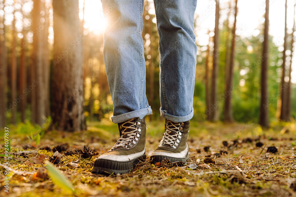 Feet of an adult wearing boots to travel walking in the forest. Feet walking in outdoor nature. Healthy lifestyle on leisure activity. Feet of an adult wearing boots to travel walking in the forest. Feet walking in outdoor nature. Healthy lifestyle on leisure activity.