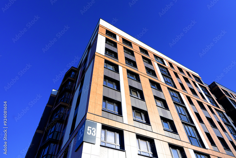 Building exterior on blue sky. New house, home complex. Facade building background. Modern building, houses with glass windows. New Buildings architecture. European residential apartment. Condominium