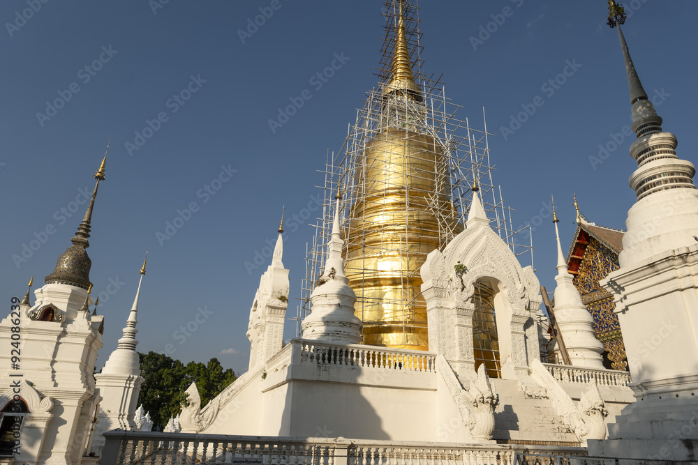 Fototapeta premium Whitewashed chedi of Wat Suan Dok covered with bamboo scaffolding in Chiang Mai, Thailand