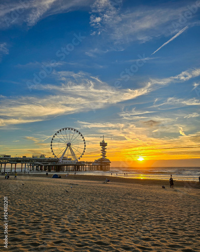 Bild auf Leinwand Sunset sky at scheveningen beach with pear and ferris wheel in the background