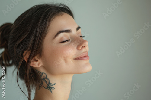 A close up of a woman's face with tattoos and her eyes closed