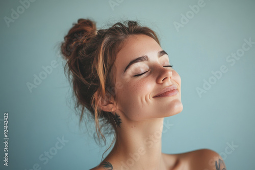 A close up of a woman's face with tattoos and her eyes closed