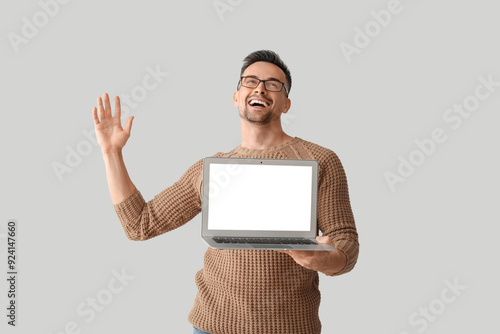 Happy young man with laptop...