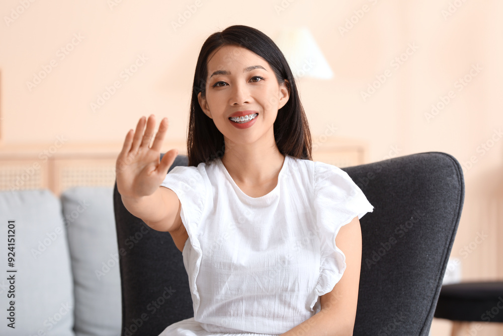 Beautiful young Asian woman waving hand at home Beautiful young Asian woman waving hand at home