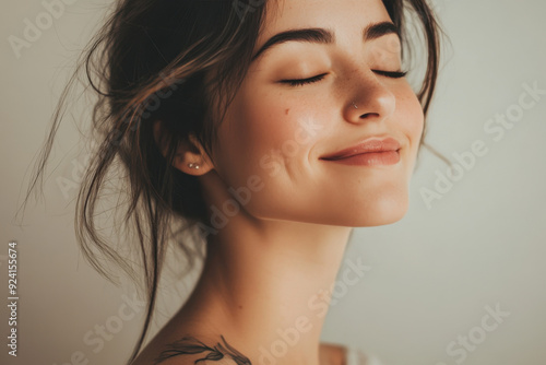 A close up of a woman's face with tattoos and her eyes closed