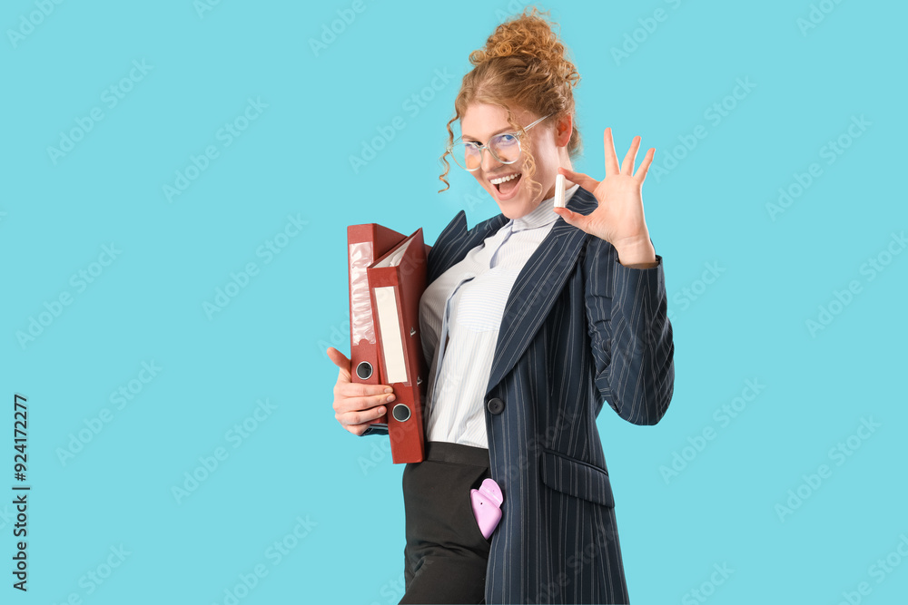 Young businesswoman with folders and tampon on blue background Young businesswoman with folders and tampon on blue background