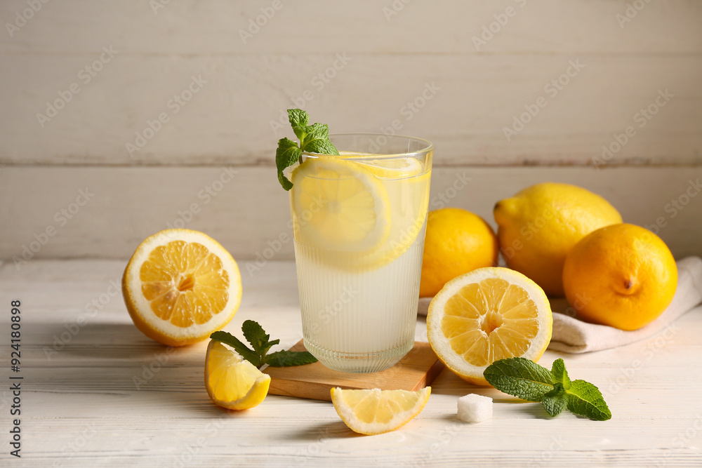 Glass of fresh lemonade with mint on white wooden background Glass of fresh lemonade with mint on white wooden background