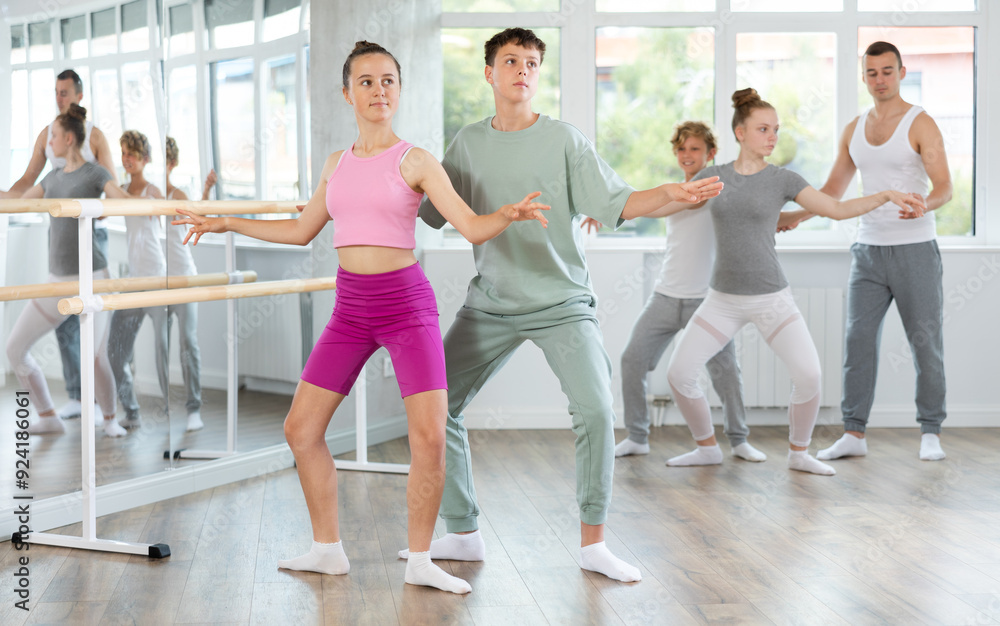 Fototapeta premium Ballet studio - teenagers learn ballet movements in pairs