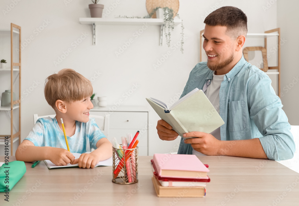 Cute boy with his father doing homework at home Cute boy with his father doing homework at home