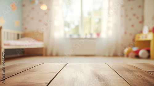 empty wooden table in the foreground. blurred background of a cozy bright children's room with large windows