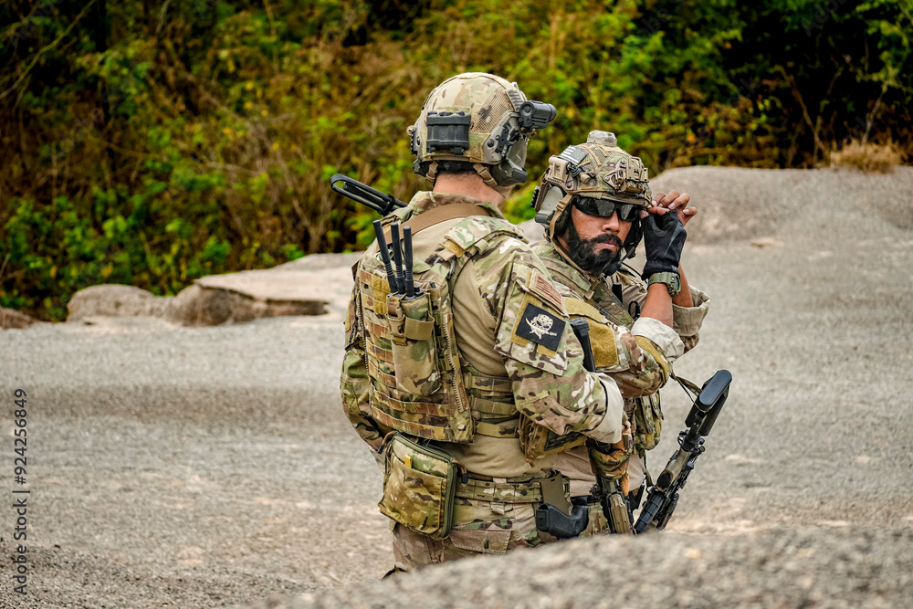 A group of military men in combat gear patrol in the middle of a desert and tropical jungle. Soldiers in full combat gear in dry weather conditions assemble and march on a mission. A group of military men in combat gear patrol in the middle of a desert and tropical jungle. Soldiers in full combat gear in dry weather conditions assemble and march on a mission.