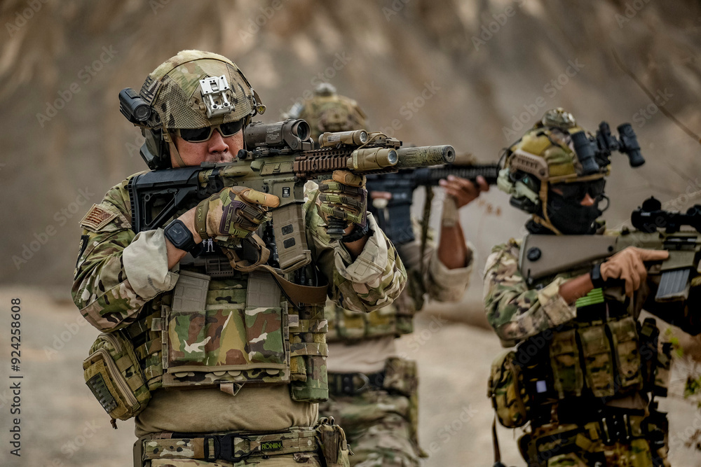 A group of military men in combat gear patrol in the middle of a desert and tropical jungle. Soldiers in full combat gear in dry weather conditions assemble and march on a mission. A group of military men in combat gear patrol in the middle of a desert and tropical jungle. Soldiers in full combat gear in dry weather conditions assemble and march on a mission.