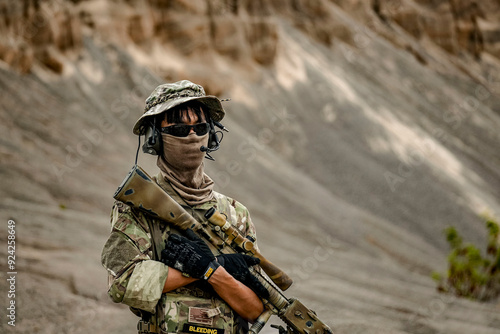 A group of military men in combat gear patrol in the middle of a desert and tropical jungle. Soldiers in full combat gear in dry weather conditions assemble and march on a mission.