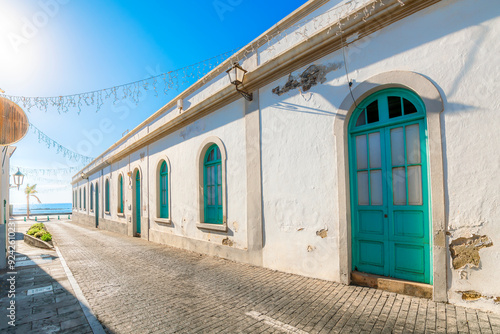 A street of turquoise doorways and windows leading to the sea in the historic old town of Arrecife, Spain, on the Canary Island of Lanzarote.