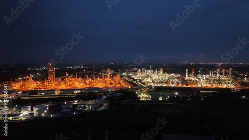 High angle view of industrial plant with pipes and tanks for mixing chemicals and gases at night.