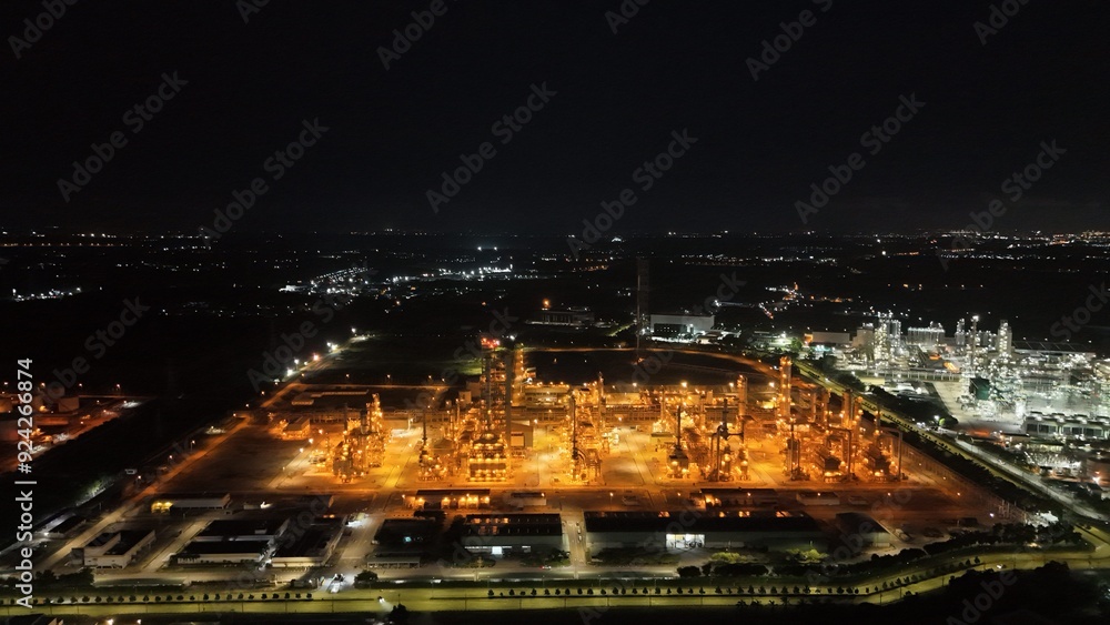 Naklejka premium High angle view of industrial plant with pipes and tanks for mixing chemicals and gases at night.