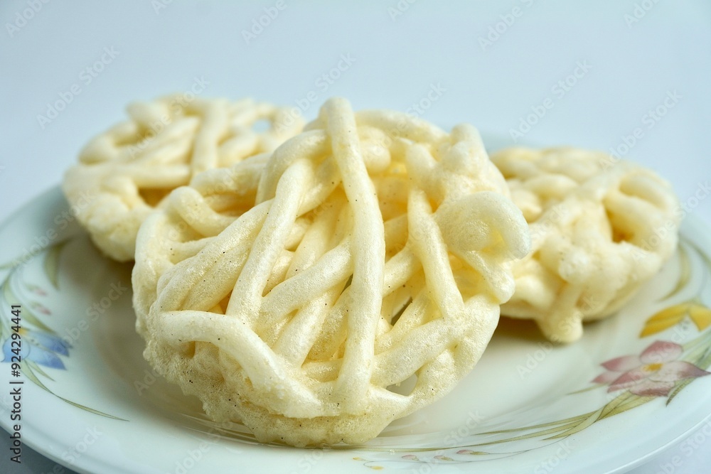Three white kerupuk mawar putih warung crackers on white porcelain plate. Food object photography isolated on white background. Three white kerupuk mawar putih warung crackers on white porcelain plate. Food object photography isolated on white background.
