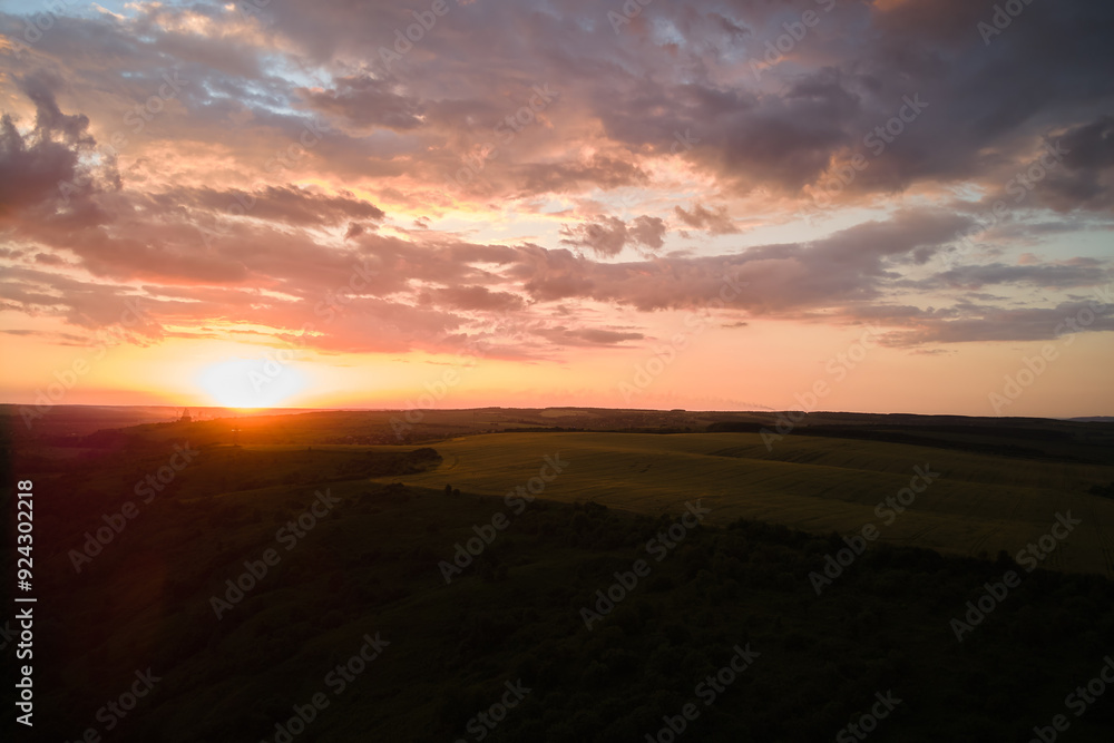 Aerial landscape view of yellow cultivated agricultural field with ripe wheat on vibrant summer evening Aerial landscape view of yellow cultivated agricultural field with ripe wheat on vibrant summer evening