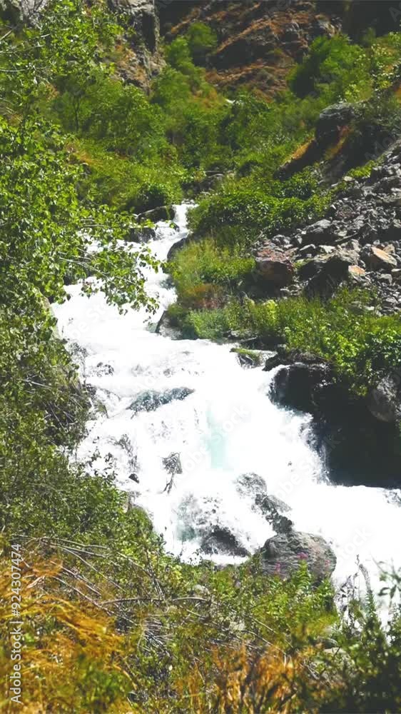 The flow of a cold turbulent mountain river down a gorge with white water saturated with air and oxygen bubbles. Stock vertical video stylized as outdated video formats in the early 2000s The flow of a cold turbulent mountain river down a gorge with white water saturated with air and oxygen bubbles. Stock vertical video stylized as outdated video formats in the early 2000s