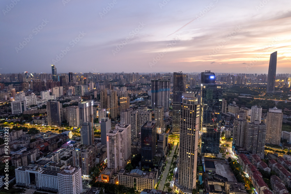 Obraz premium Stunning Urban Cityscape at Sunset with Twinkling Lights