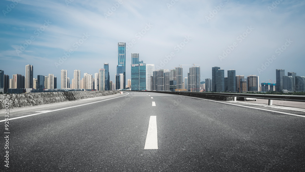 Naklejka premium Expansive Urban Highway with City Skyline in the Background