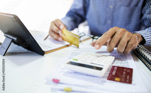 Asian man calculate the expenses and business cost to be pay after use credit card for start new business