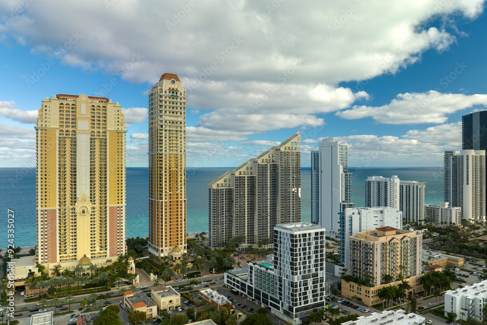 High angle view of Sunny Isles Beach city with expensive highrise hotels and condo buildings on Atlantic ocean shore. American tourism infrastructure in coastal southern Florida High angle view of Sunny Isles Beach city with expensive highrise hotels and condo buildings on Atlantic ocean shore. American tourism infrastructure in coastal southern Florida