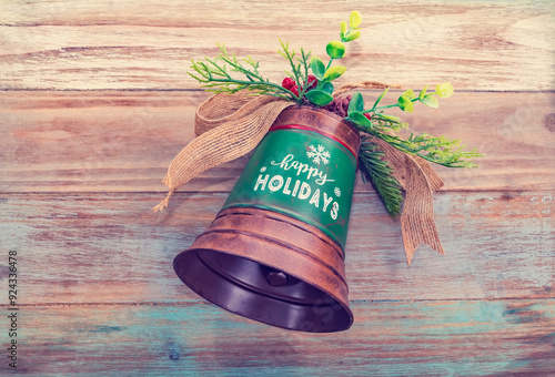 Christmas bells with word happy holiday on wooden background photo