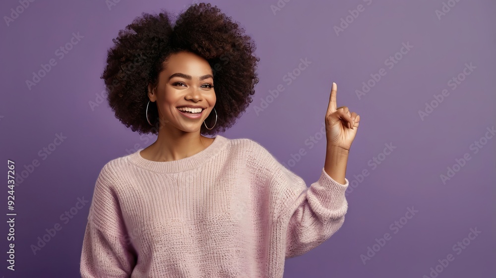 Photo of delighted cheerful Afro American woman with crisp hair, points away, shows blank space, happy to advertise item on sale, wears orange jumper Photo of delighted cheerful Afro American woman with crisp hair, points away, shows blank space, happy to advertise item on sale, wears orange jumper