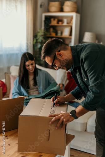 Happy young couple unpacking or packing boxes and moving into a new home