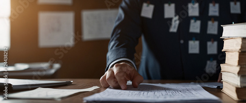 A worried manager brainstorming ideas, surrounded by hand holding documents. The image showcases the effort and creativity needed to overcome challenges and find solutions under tight deadlines photo