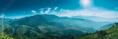 A breathtaking panoramic photo showcases the lush green mountains under a vibrant blue sky, capturing the essence of nature's beauty.