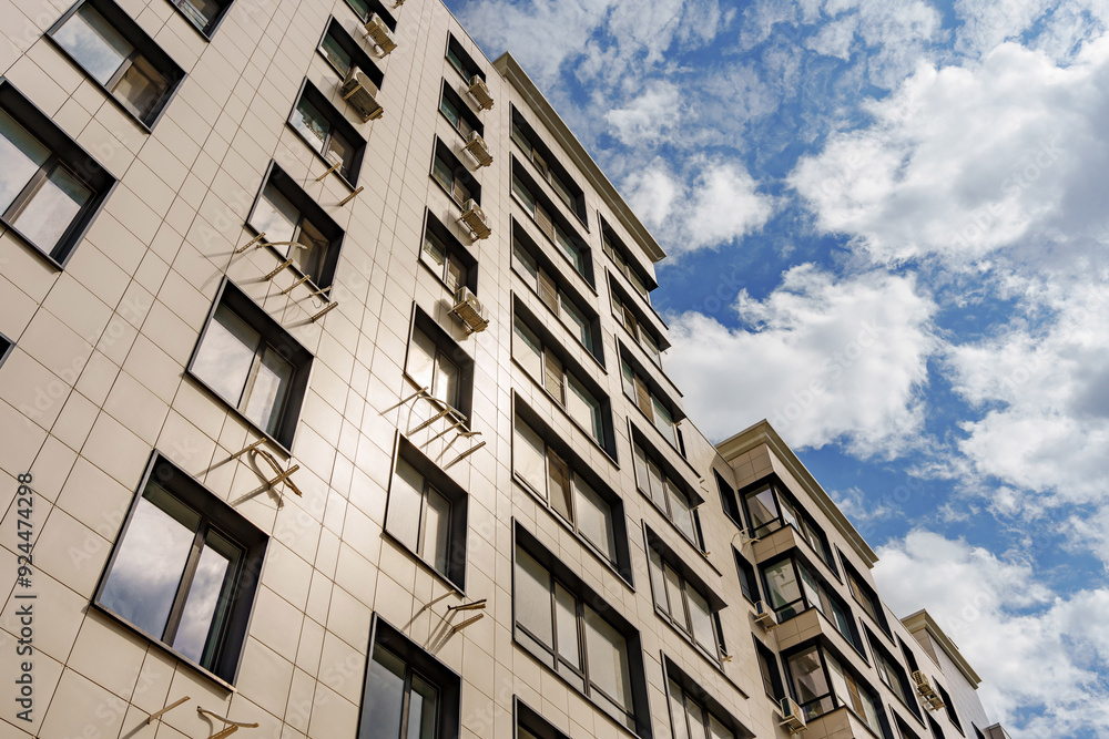 A multi-storey modern building against the background of the sky with clouds. A multi-storey modern building against the background of the sky with clouds.