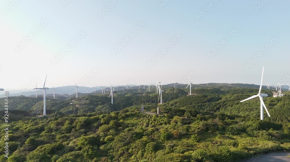 A cluster of wind turbines for generating electric power in a valley surrounded by green forest. wind generator Environmentally sustainable energy concept. Top view from a drone A cluster of wind turbines for generating electric power in a valley surrounded by green forest. wind generator Environmentally sustainable energy concept. Top view from a drone