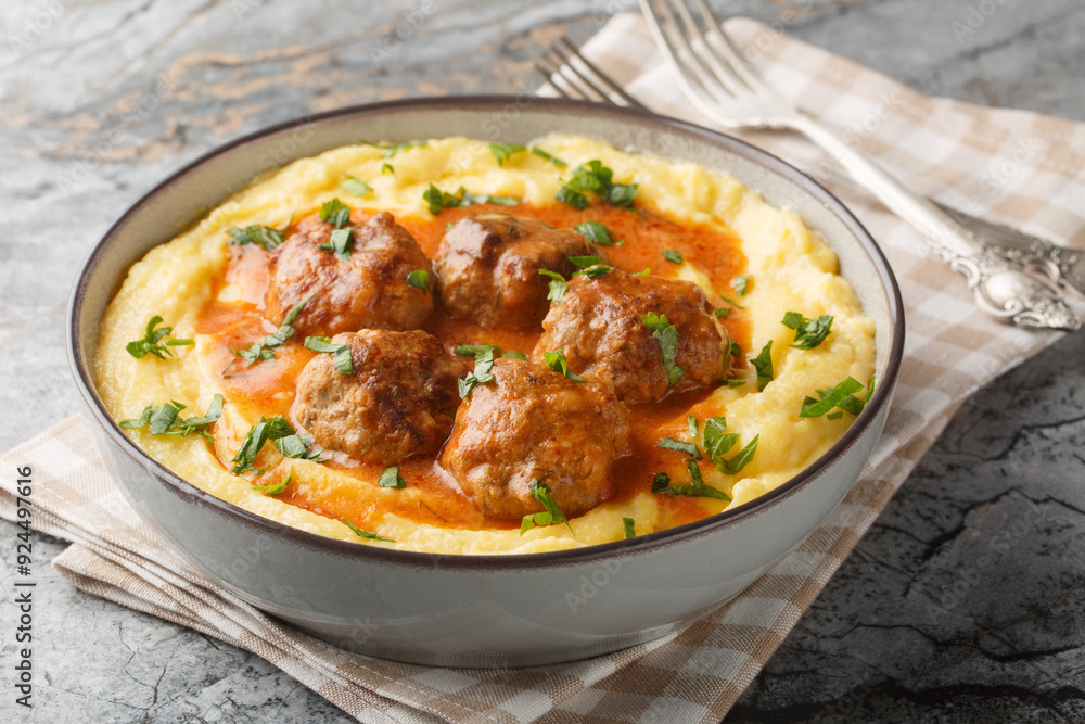 Classic Italian meatballs with creamy polenta closeup on the bowl on the table. Horizontal Classic Italian meatballs with creamy polenta closeup on the bowl on the table. Horizontal
