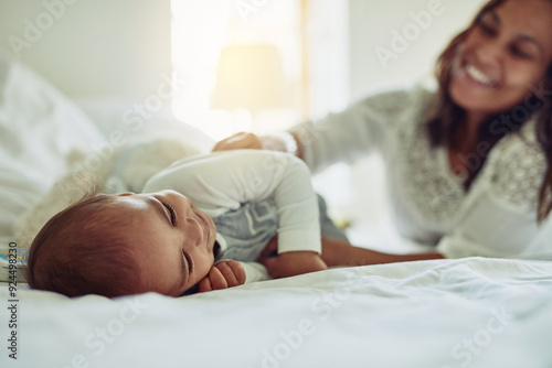 Baby, relax and bed with mother at house for play, family bonding and care together of childhood growth. Smile, child and fun with woman for support, love and trust of relationship development