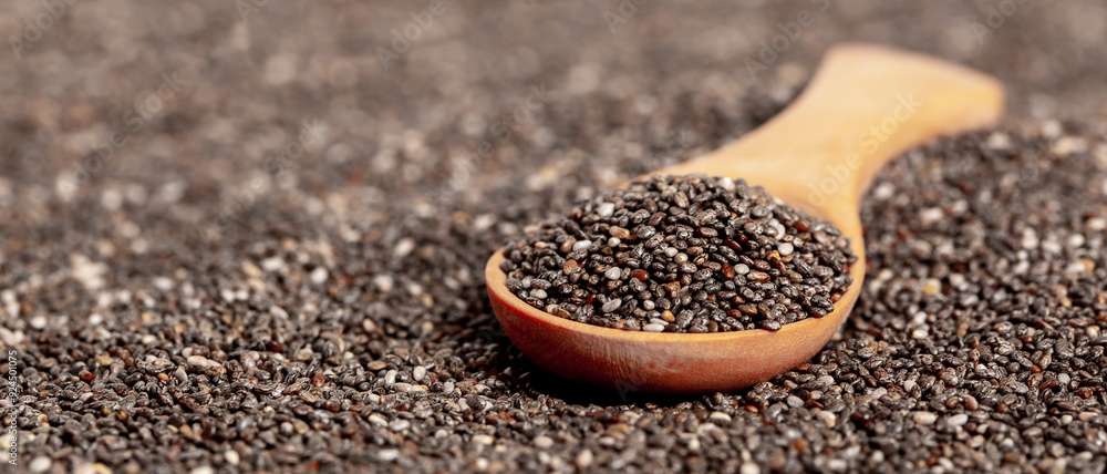 Chia seeds close-up with a wooden spoon. Chia seeds macro. Dry healthy supplement for proper nutrition. Chia seeds close-up with a wooden spoon. Chia seeds macro. Dry healthy supplement for proper nutrition.