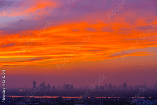 Evening view of city silhouettes of buildings and skyscrapers, the dying sky after sunset and amazing red clouds