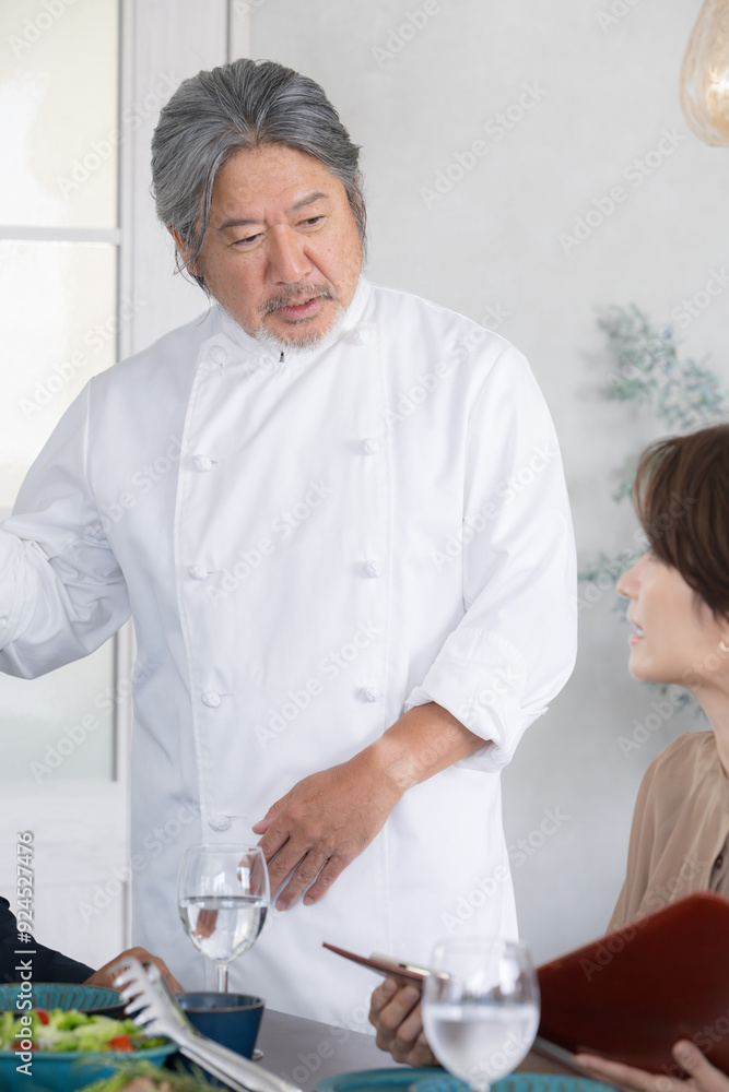 Obraz premium コックコートを着た男性シェフのイメージ 料理のシェフの説明