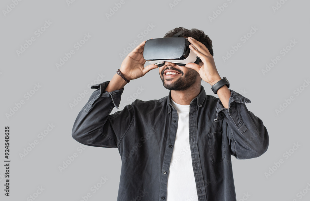 Young man using virtual reality headset isolated on gray background, VR, future gadgets, technology, virtual event, video game concept Young man using virtual reality headset isolated on gray background, VR, future gadgets, technology, virtual event, video game concept