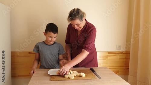 Cut the potato and sausage roll into pieces with a knife. photo