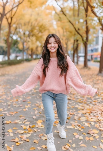Young Woman Joyfully Playing With Autumn Leaves in a Park During Fall