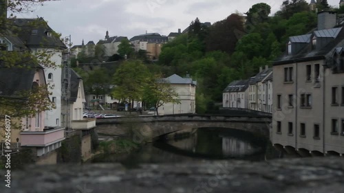 Sunset in the old european city the capital of Grand Duchy of Luxembourg. Burgundy red sky reflects in the water of Alzette river in Grund quarter Pfaffenthal district of Old Town in Luxembourg photo