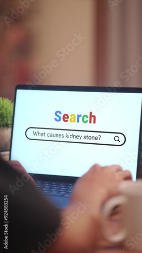 VERTICAL VIDEO OF MAN SEARCHING WHAT CAUSES KIDNEY STONE? ON INTERNET