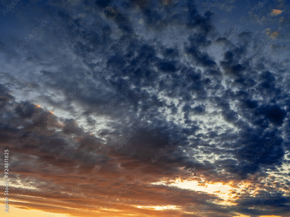 Fototapeta premium Cloudy blue dramatic sunset sky. Nature background for design and replacement. Warm and cold color tone