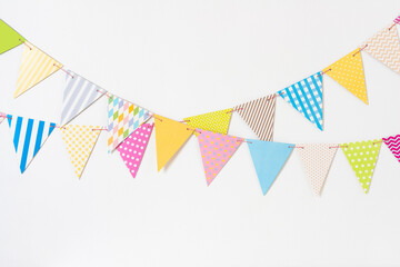 Two decorative colorful pennant garlands on white wall background for birthday celebration, festival or carnival