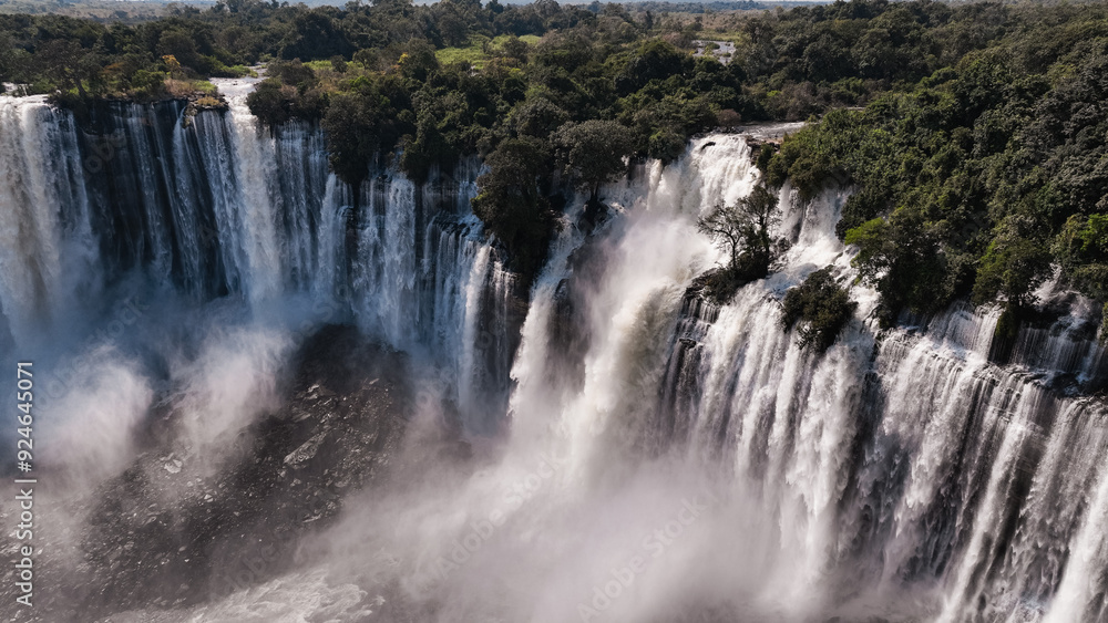 Kalandula Waterfall cascades in Angola surrounded by lush greenery during daylight Kalandula Waterfall cascades in Angola surrounded by lush greenery during daylight
