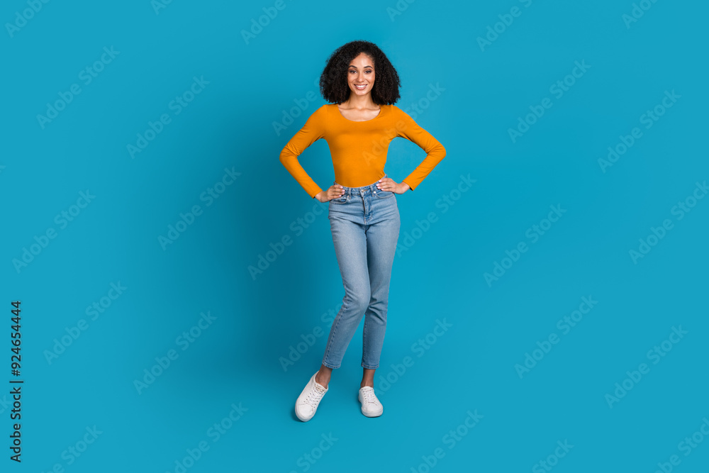 Full size photo of pretty young girl posing model wear trendy yellow outfit isolated on blue color background Full size photo of pretty young girl posing model wear trendy yellow outfit isolated on blue color background