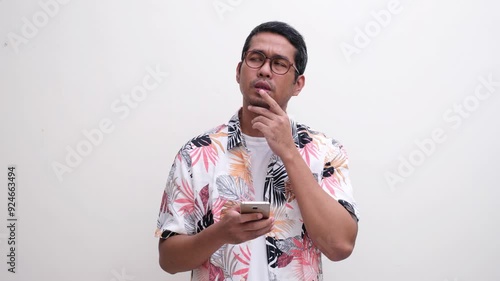 A man try to remember something when texting using mobile phone